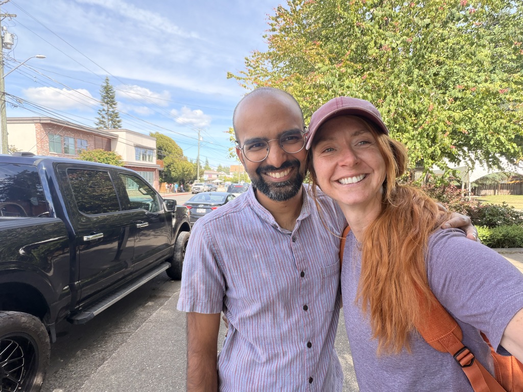 Two members taking a selfie on a sunny street after their coffee